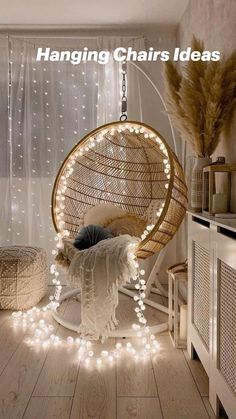 a hanging chair with lights around it in a room that has white curtains and wooden floors