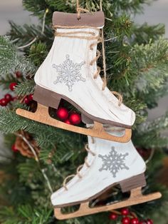 an ornament hanging from a christmas tree with two ice skates on it