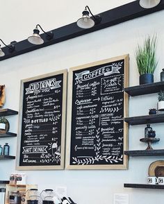 two blackboard menus mounted to the wall above a coffee shop's counter