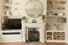 a living room filled with furniture and a flat screen tv on top of a fireplace