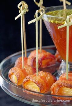 small appetizers are arranged on a plate with toothpicks and sauces