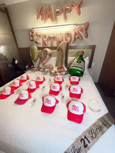 a bed with red and white hats on top of it next to a happy birthday sign