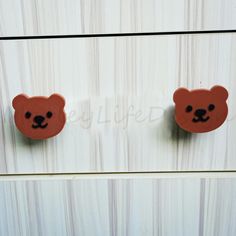 two brown teddy bears are attached to the wall with magnets on it's sides