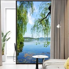 an open door with a view of the water and trees on it in front of a window