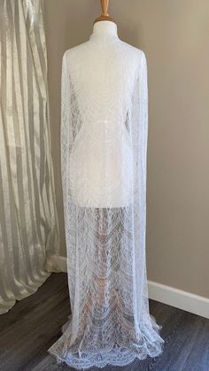 "Chantilly lace cape in off-white shade Unique fabric design with a chandelier-like motif giving an Art Deco vibe Fitted shoulders with soft gathers The cape is edged with eyelash scallop edge - very feminine Finished length is 60\" from shoulders A one-of-a-kind design💕" Sheer Lace Wedding Night Gown, Sheer Long Wedding Dress, Elegant Sheer Lace Dress For Wedding, Long Sheer Wedding Dress, Elegant Sheer Lace Wedding Dress, Long Sheer Lace Dress, Wedding Night Gown With Scalloped Lace, White Long Gown With Lace Trim, Sheer Lace Dress For Mother Of The Bride