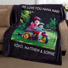 a black blanket with a photo of two children on a toy car and the words, we love you nanna mary