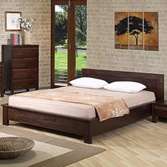 a bed room with a neatly made bed and wooden furniture in front of a brick wall