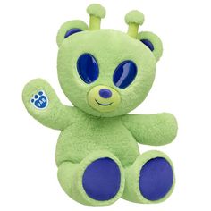 a green teddy bear with blue eyes on it's head and paws up in the air