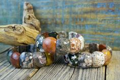 Each bead in this gorgeous Ocean Jasper bracelet is a mini-masterpiece! The colors are a unique mix of earthy tones and the patterns on each stone bead are unique. Each bracelet is truly one-of-a-kind! (7.5" x .75" wide) Ocean Jasper is a protective, multi-colored stone with spherical patters that are said to hold ancient mystic knowledge and wisdom. It has a gentle and nurturing energy. This stone can help reveal and facilitate the healing of unresolved emotions, inspiring peace and happiness. Earthy Jasper Beaded Bracelet With Natural Stones, Earthy Jasper Beaded Bracelets With Natural Stones, Earthy Beaded Bracelets With Natural Jasper Stones, Earthy Jasper Beaded Bracelets, Earthy Brown Jasper Beaded Bracelets, Earthy Jasper Gemstone Bead Bracelets, Earthy Jasper Round Bead Bracelets, Earthy Jasper Gemstone Beads Bracelet, Bohemian Jasper Beaded Bracelets With Natural Stones