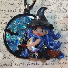 a necklace with a little witch sitting on top of it