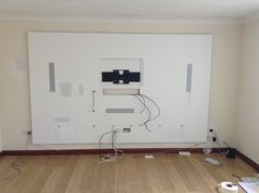 an empty room with some wires on the wall and other electrical equipment in the floor