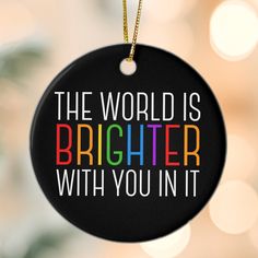 a black ornament with the words, the world is brighter with you in it