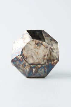 a marbled object is sitting on a white surface and it looks like hexagonal