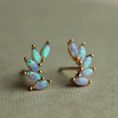 These delicate opal stud earrings are made of turquoise and blue opal and gold plated sterling silver, formed into tiny wings or crescents. They have an amazing glowing quality and when they catch the light, flecks of gold and turquoise light up from within. They are really beautiful and unusual. The stud or post earrings measure 10mm in length. The opals are set into gold plated sterling silver. The butterfly backs are made from gold plated sterling silver. These stud earrings come mounted on a Alchemy Jewelry, Opal Stud Earrings, Jewelry Ads, Opal Earrings Stud, Precious Jewels, Opal Studs, Wing Earrings, Pretty Stuff, Opal Earrings