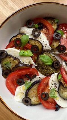 a white bowl filled with lots of different types of food on top of a wooden table