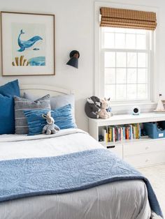 a bed room with a neatly made bed and a book shelf on the wall next to it