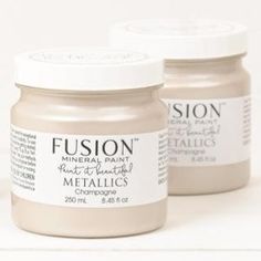 two jars of metallic paint sitting next to each other on a white surface with the words fusion written in it