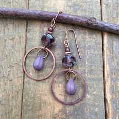 Small purple dangle drop earrings. Lightweight, everyday Czech glass earrings with rustic teardrop dangle and antiqued copper.Small, light-weight copper and Czech glass earrings that are perfect for your summer jewelry collection! The focal piece is a beautiful, faceted purple Czech glass rondelle shaped bead and small glass teardrop dangle in an antiqued copper ring.Product overview:- Made with Czech glass and antiqued copper- Total hanging length is 2", the ring is the diameter of a penny- Sma Artsy Earrings, Purple Drop Earrings, Hammered Copper Earrings, Orange Jewelry, Glass Drop Earrings, Copper Accents, Copper Ring, Purple Earrings, Wrapped Jewelry