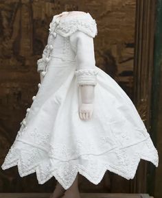 a doll dressed in white is standing up