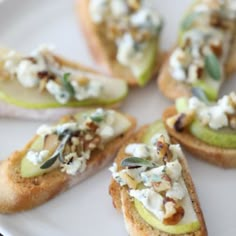 several appetizers are arranged on a white plate, including pears and goat cheese