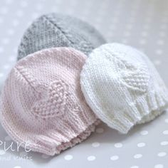 three knitted hats sitting on top of a table