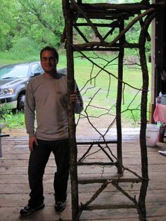 a man standing in front of a wooden structure