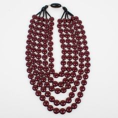 This superb Angela Caputi, made-in-Italy resin choker necklace features an oversized multi-strand design with lovely red Bordeaux and black colors. The geometric flat and slightly domed rounded pebbles (they look like Smarties) are built in five cascading raws. Her color matching is always extremely classy, perfect for casual and fancy occasions. As you know, Caputi jewelry is not signed. This is a pre-owned necklace. The plastic tag was removed, but the piece has the brand-signature snap-closing clasp. Angela Caputi has produced resin and Lucite jewelry collections since the 1980s in Florence, Italy. Some of her pieces are at the Metropolitan Museum in New York. Measurements: The necklace's total length is 21.46 in long (54.50 cm) - The largest width is 3.19 in width (8 cm).  Please see t Red Multi-strand Beaded Necklace, Red Multi-strand Gemstone Beads Necklace, Multi-strand Red Necklace With Colorful Beads, Multi-strand Red Coral Necklace, Artisan Multi-strand Red Necklace, Lucite Jewelry, New York Museums, Multi Strand, Color Matching