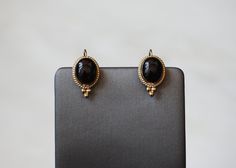 Vintage Circa 1980 in an Etruscan Style Constructed completely of 14 Karat Gold *Electronically tested for metal purity.  Containing 2 Bezel set Oval Cabochon cut pieces of Genuine Earth-Mined Black Onyx Each earring measuring approximately 0.75" in length Earrings weighing a total of 2.3 grams *Sale includes an Appraisal Certificate for buyer's insurance purposes / proof of ownership. All pieces shipped insured via USPS Priority Mail requiring signature upon delivery.  Specialty gift wrap upon Black Cabochon Earrings For Evening, Evening Black Cabochon Earrings, Formal Black Brass Earrings, Vintage Black Earrings For Anniversary, Antique Black Earrings For Formal Occasions, Onyx Earrings, Drop Dangle Earrings, Earrings Vintage, Oval Cabochon