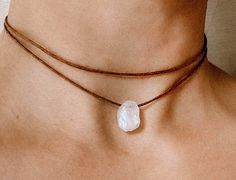 "As a stone for \"new beginnings\", moonstone is a stone of inner growth and strength. It promotes intuition, gives dreams and leads to balance.  This is a raw moonstone choker in a minimalistic look. Fully adjustable with a sliding bead on a high quality brown cotton cord.  ✦ MORE COLORS follow the links below ✦ BLACK https://www.etsy.com/de/listing/1534647969/roher-mondstein-choker-mondstein?click_key=663ae96dacc0e2f8ed138736038cab763e64a8ba%3A1534647969&click_sum=677c964f&ref=shop_home_active_29&frs=1 BEIGE https://www.etsy.com/de/listing/1534641915/roher-mondstein-choker-mondstein?click_key=e341cd911f44d6b0e493ff3f416987b7132032ed%3A1534641915&click_sum=fd7fa706&ref=shop_home_active_30&frs=1 ✦ MATERIAL | COLOR ✦ Raw moonstone Stone size: 12-15mm BROWN waxed cotton cord ✦ LOOK ✦ Two Lay Minimalist Adjustable Crystal Necklace With Natural Stones, Minimalist Crystal Necklace With Natural Stones, Adjustable White Gemstone Crystal Necklace, Adjustable Moonstone Crystal Necklaces For Meditation, Adjustable White Crystal Gemstone Necklace, Adjustable Moon Charm Necklace For Healing, Adjustable White Necklace With Moon Charm, White Adjustable Crystal Gemstone Necklace, Adjustable Spiritual Moonstone Crystal Necklace