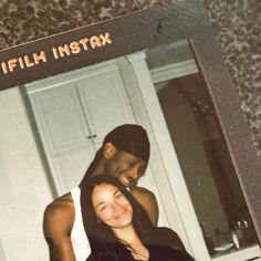 an old photo of a man and woman hugging each other in front of a mirror