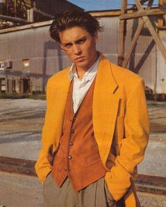 a young man in an orange blazer and tan pants