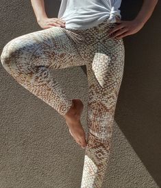 Yoga pants Aztec print in White and Gold. Buttery soft and comfortable, made out of moisture wicking microfiber. Four-way stretch made to withstand the most strenuous stretching and exercise. Feminine, nature inspired print. Available in regular waist and high waist (yoga leggings - as pictured), with a crotch gusset to prevent ripping and a high waistband that keeps you covered and provides a gentle tummy tuck.    * 82% polyester/18% spandex  * Squat proof, body sculpting  * Printed and hand sewn in California and Latvia - sweat shop free  * Shipping worldwide, free shipping on all US orders. Size guide:                             |  XS  |   S   |   M    |   L   |  XL Waist (inches) | 25 ¼ | 26 ¾ | 28 ⅜ | 31 ½ | 34 ⅝ Hips (inches) | 35 ⅜ | 37 | 38 ⅝ | 41 ¾ | 44 ⅞                     | XS Printed Stretch Activewear For Athleisure, Stretch Printed Activewear For Workout, Printed Stretch Activewear For Workout, Stretch Printed Bottoms For Yoga, Feminine Nature, Aztec Leggings, High Waisted Leggings Workout, Gold Leggings, Leggings Gym