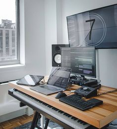 there is a desk with two computers on it and a keyboard in front of the monitor