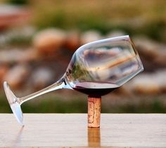 a wine glass sitting on top of a wooden table