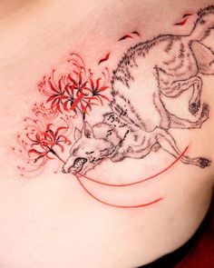 a woman's chest with a wolf and flowers tattoo design on the left side