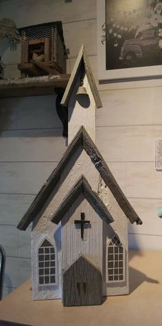 a small wooden church with a cross on the roof