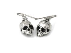 We wanted these skulls to be a little more realistic and spooky than our other human skull earrings and we think that we pulled it off nicely! The design was carved by hand in wax and then molded and cast in metal. The skull charms are cast in Lead Free Pewter and weighs a bit under 5 grams each. They are about 13 mm long (just over half an inch) and dangle from Stainless Steel earring hooks. They are oxidized to fill in the details and then polished. For more of our skull earrings please look h Gothic Skull Earrings For Halloween, Punk Skull Print Earrings Gift, Punk Skull Print Earrings For Gift, Punk Style Skull Print Earrings As Gift, Halloween Skull Print Skull Earrings, Nickel-free Skull Earrings In Punk Style, Silver Skull Earrings For Halloween, Gothic Skull Print Earrings As Gift, Gothic Skull Print Earrings For Gift