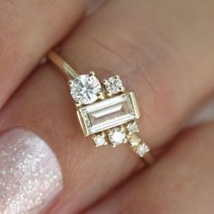 a close up of a person's hand with a diamond ring on their finger