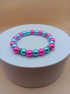 Aqua and pink 8mm pearl bead bracelet. It is a very colorful bracelet that can make a nice gift for your loved ones or for yourself.  Bracelet is crafted with quality elastic stretch cord for the perfect fit. Bracelet sizes are from 6.5 inches to 8 inches. If your wrist size is not listed then please contact me with your wrist size. I will gladly do a special order. All items are made to order. They are shipped via United States Postal Service with a tracking number. Items will be shipped within Pearl Beaded Bracelets With 8mm Beads As A Gift, Pink Beaded Bracelets With 8mm Beads For Birthday, Pink Beaded Party Bracelets, Turquoise Pearl Bracelet As A Gift, Pearl Bracelets For Birthday, Pearl Bracelets With Round Beads For Birthday, Pearl Bracelet With Round Beads For Birthday, Handmade Pink Stretch Bracelet For Birthday, Pink Round Bead Bracelets For Birthday Gift