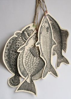 two fish hanging from strings on a wall