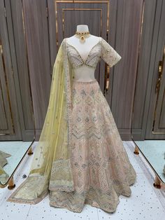 Be the daring bride and steal the show with our Bridal Lehenga BL-283! In a stunning peach color with intricate mirror work, this lehenga is perfect for your sangeet night. Make a statement and embrace your adventurous side with this bold and beautiful piece! Fabric: Organza! WASH CARE INSTRUCTIONS - Please Dry clean only when it is applicable! Ready to Ship! Bollywood Traditional Wear With Intricate Embroidery In Peach, Bollywood Style Peach Traditional Wear With Intricate Embroidery, Festive Peach Sharara For Wedding, Peach Sharara With Zari Work For Wedding, Peach Bollywood Dress With Zari Work, Wedding Lehenga With Dori Work, Floor-length, Bollywood Style Peach Traditional Wear With Dori Work, Traditional Peach Choli With Dori Work, Wedding Gown With Cutdana On Chinon