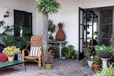 an outdoor patio with potted plants and chairs