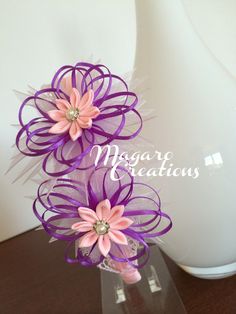 three pink and purple flowers in a clear vase