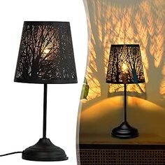 a lamp that is sitting on top of a table next to a bed with trees