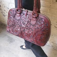 💼 This genuine leather satchel handbag, the epitome of sophistication and craftsmanship, invites you to indulge in timeless elegance. Introducing Eva, a beautiful piece of handcrafted art made from premium full-grain leather. This handcrafted purse has a unique artisanal touch. The front is embellished with elaborate floral and leaf motifs, which are tastefully balanced by a honeycomb pattern on the reverse. With our distinctive top-handle bag, which perfectly combines elegance and utility, you can easily elevate your look.💼 Enter the world of luxury with Eva's exquisitely furnished interior, which has been carefully planned to meet your needs for organization. The handbag features one central zip pocket, two convenient side pockets, and an additional zip side pocket, ensuring ample spac Elegant Rectangular Satchel With Leather Lining, Timeless Leather Bag As Gift, Timeless Leather Bag For Gift, Timeless Leather Bag For Gifts, Timeless Leather Bags Suitable For Gifts, Elegant Burgundy Handheld Satchel, Italian Leather Bag As Gift, Italian Leather Bag As A Gift, Burgundy Leather Handheld Satchel