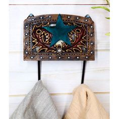 a wooden wall hanging with a star on it and two different colored towels next to it