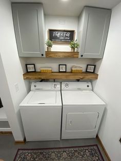 a washer and dryer in a laundry room with cabinets above the washer