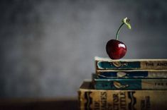 a cherry sitting on top of three books