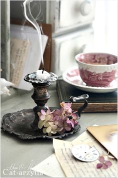 an old fashioned tea cup and saucer with flowers on the plate next to it