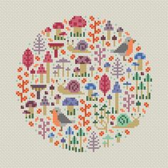 a cross stitch pattern with birds, flowers and trees in the shape of a circle